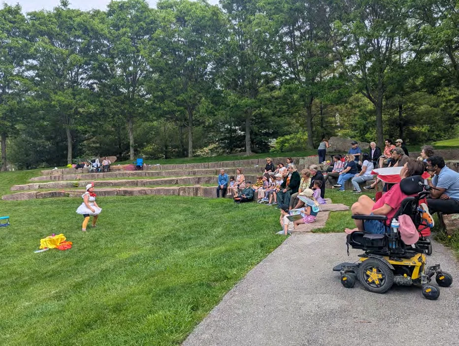 Families gathered on the grass at the amphitheatre during the Fairy Trail Walk for Esther